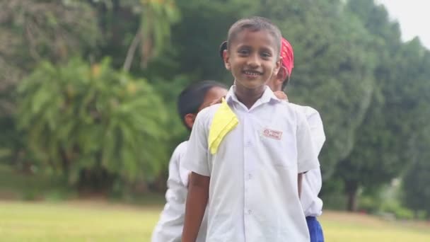 Kinderen in school uniform spelen in de botanische tuinen — Stockvideo