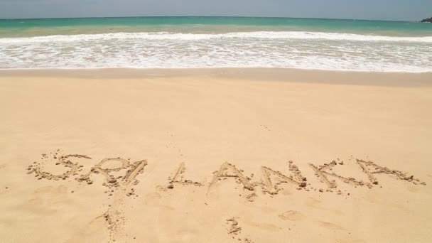 스리랑카 해변에서 모래에 작성 된 단어를 접근 하는 바다 물결 — 비디오
