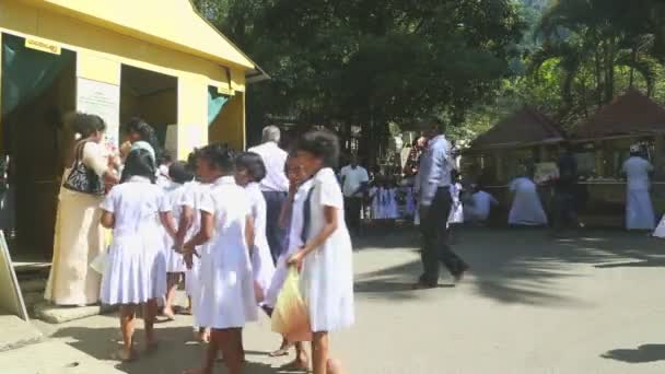 Местные жители и школьники входят в Храм Зуба — стоковое видео