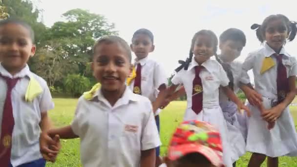 Дети в школьной форме играют в ботанических садах — стоковое видео