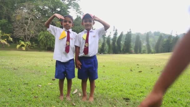 Kinderen in school uniform spelen in de botanische tuinen — Stockvideo