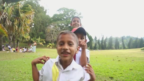 Kinderen in school uniform spelen in de botanische tuinen — Stockvideo