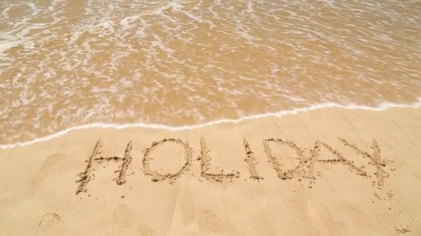 Meer Welle bedeckt Wort Urlaub in Sand am Strand geschrieben — Stockvideo