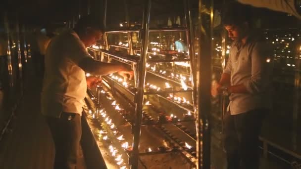 Menschen zünden Kerzen im Tempel an — Stockvideo