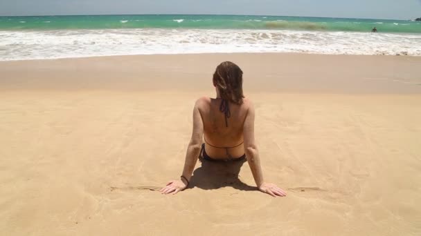 Frau liegt am Strand — Stockvideo