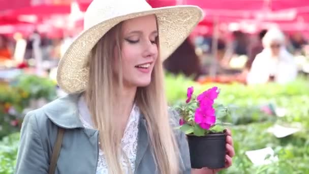 Vrouw ruikende bloemen in markt — Stockvideo