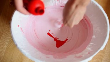 Beyaz boya kova içinde kırmızı boya karıştırma