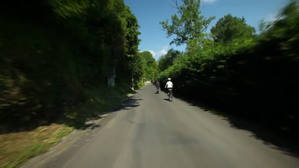 Отставная пара катается на велосипеде по дороге в сельской местности — стоковое видео