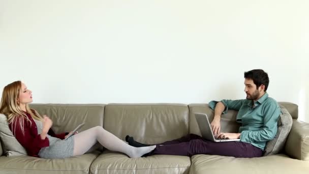 Frau auf Couch spricht Mann an — Stockvideo