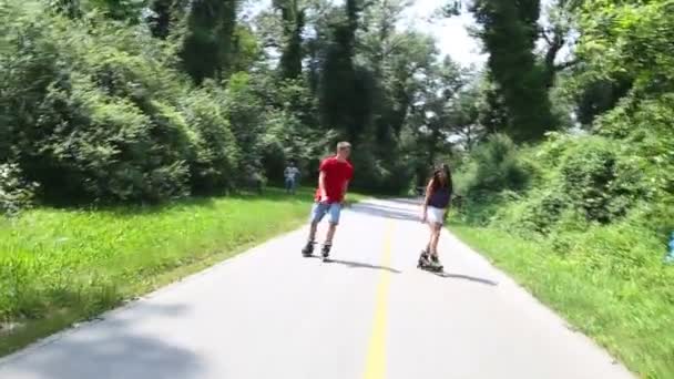 Woman and man rollerblading in park — Stock Video