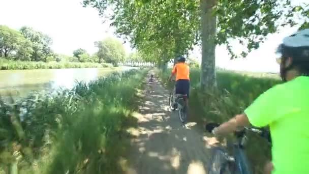 Чоловік їде на велосипеді вздовж брудної доріжки — стокове відео