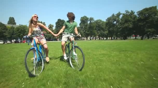 Couple cycling through park — Stock Video