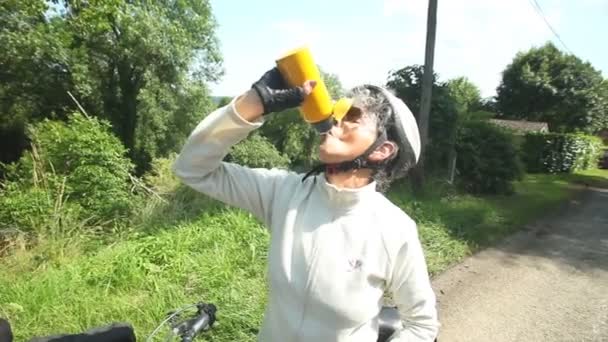 Mujer ciclista descansando para beber — Vídeo de stock
