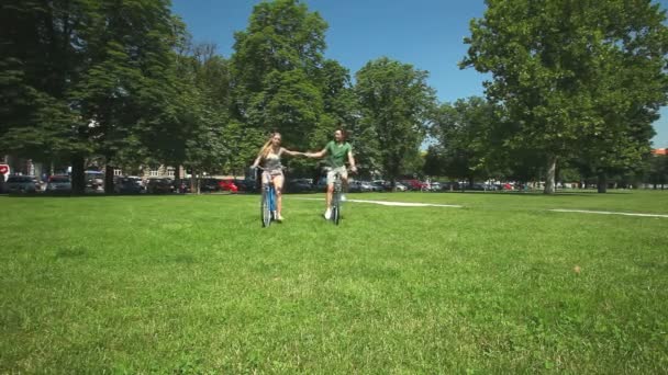 Paar genieten van fietsen door park — Stockvideo