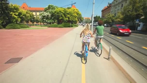 Par njuter av cykling genom park — Stockvideo