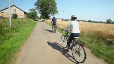 Yolda bisiklet süren çift