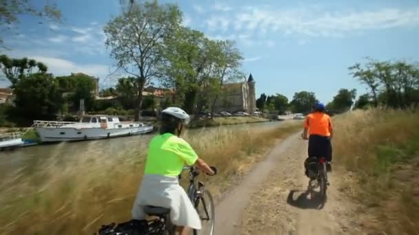 Paar fietsen langs rivier — Stockvideo