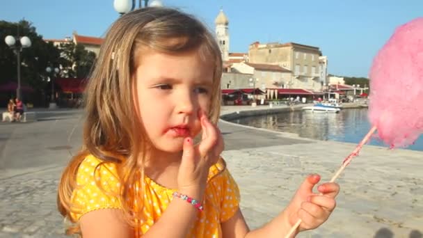 Linda niña comiendo hilo dental de caramelo — Vídeos de Stock