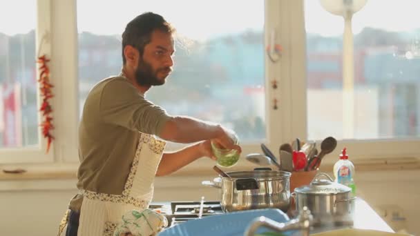Человек готовит обед на кухне — стоковое видео