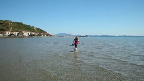 Woman running in sea water on beach — Stock Video