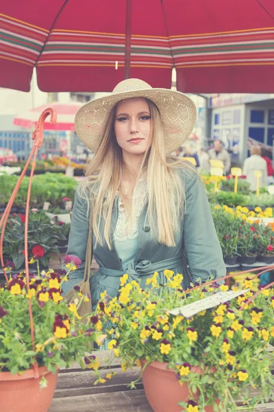 Girl with straw hat on flower marketplace — Stock Photo, Image