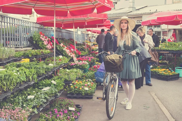 Blonde girl with straw hat and bike — Stock Photo, Image