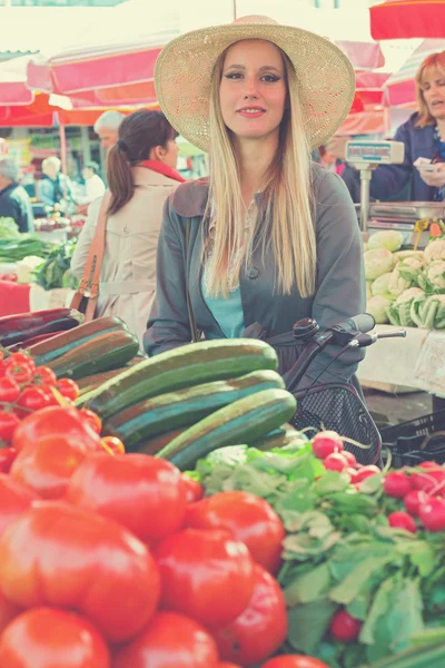 Привлекательная блондинка в соломенной шляпе позирует на рынке . — стоковое фото