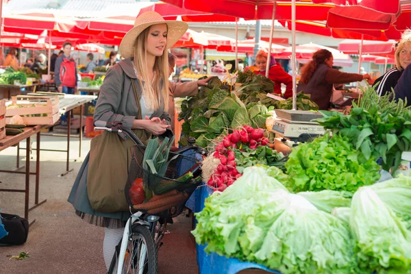 Attraente donna bionda con cappello di paglia e bici su Marketplace . — Foto Stock