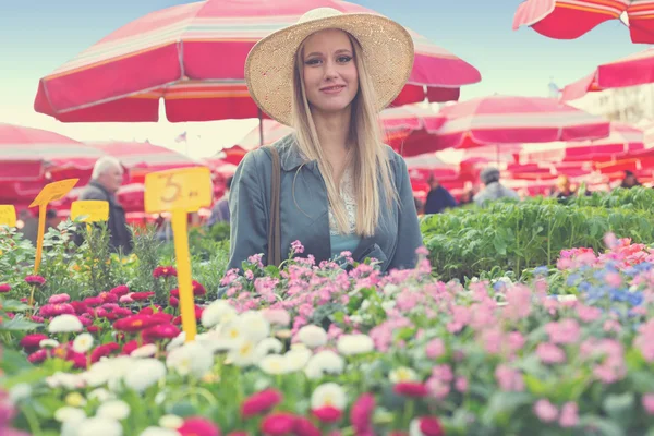 Girl with straw hat on flower marketplace — Stock Photo, Image