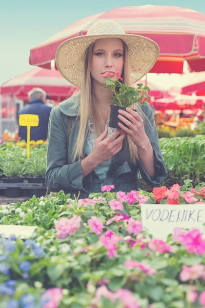 Girl with straw hat holding flower pot — Stock Photo, Image