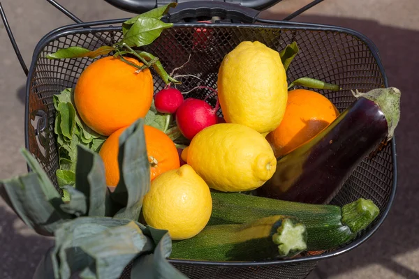Kosz rowerowy pełen świeżych owoców i warzyw z marketplace. — Zdjęcie stockowe
