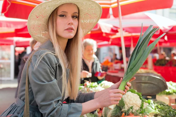 Attractive blonde girl with straw hat buying vegetables on  marketplace. — Stock Photo, Image