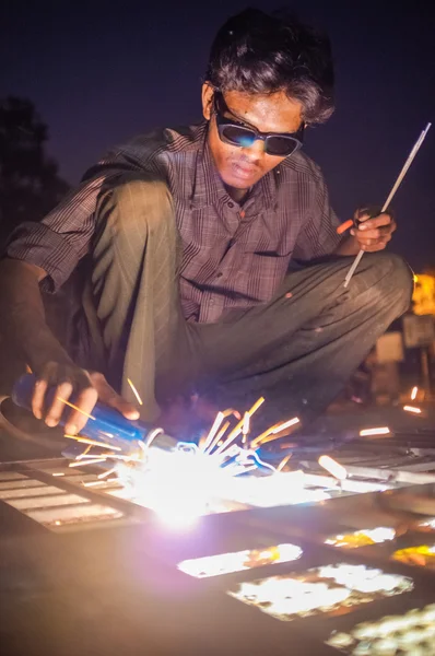 Indian worker welding metal parts — Stock Photo, Image