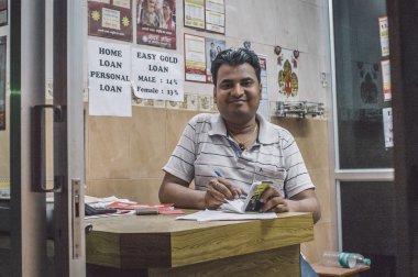 Hintli adam altın kredi ofisinde oturuyor