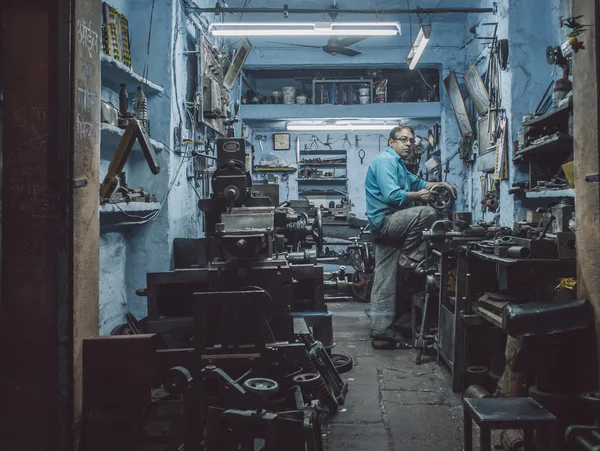 Mecánico trabajando hasta tarde en el taller — Foto de Stock