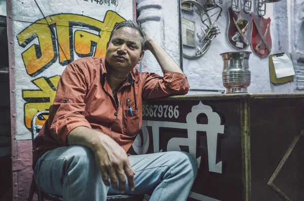 Владелец индийского магазина сидит на стуле — стоковое фото