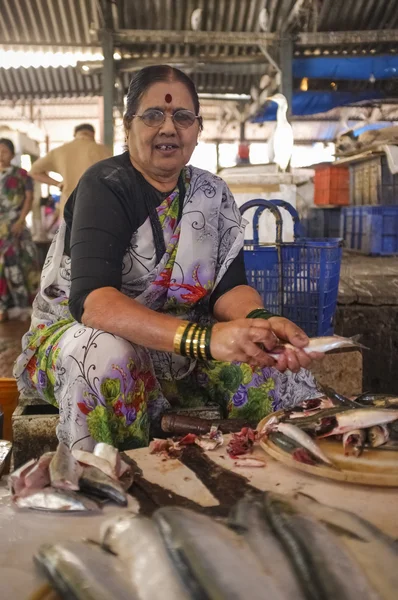 Mulher limpando peixes no mercado de peixe . — Fotografia de Stock