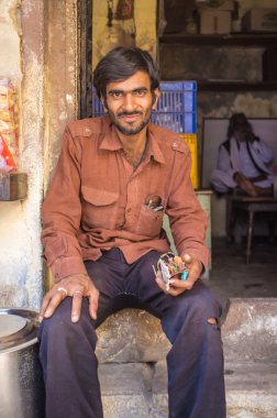 Hint elektrikçi dükkanının önünde duruyor