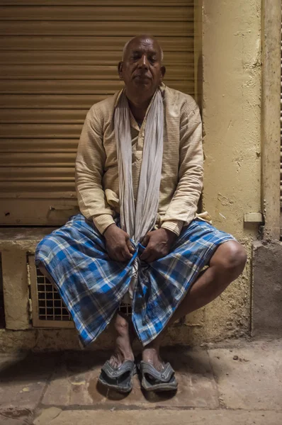 Indian man sitting next to closed store — Stock Photo, Image