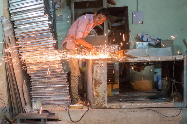 Indischer Arbeiter feilt an Metallteil — Stockfoto