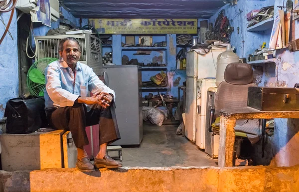 Anciano electricista se sienta en la nevera —  Fotos de Stock