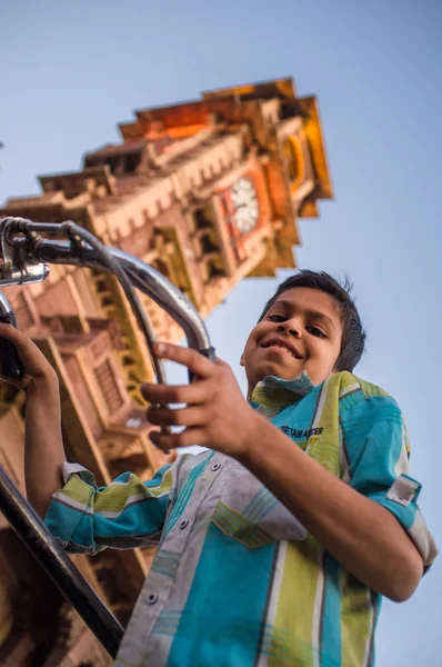 Chlapec na kole pod ghanta ghar — Stock fotografie