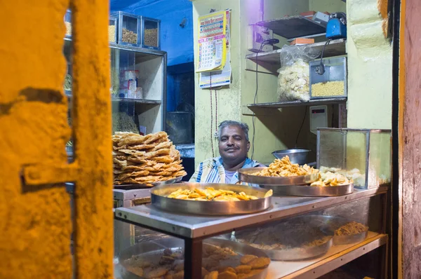 Vendedor se sienta en la tienda con comida — Foto de Stock