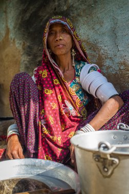 Rabari tribeswoman  cleans dishes