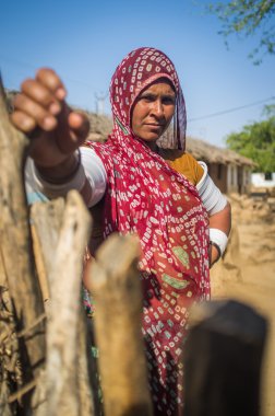 Rabari tribeswoman holds gate