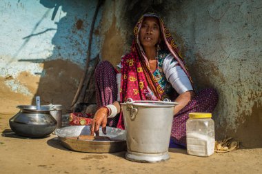 Rabari tribeswoman cleans dishes