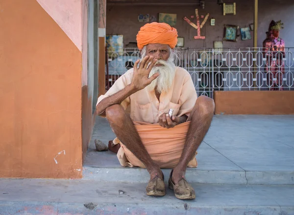 Elderly tribesman sits on ground — стокове фото
