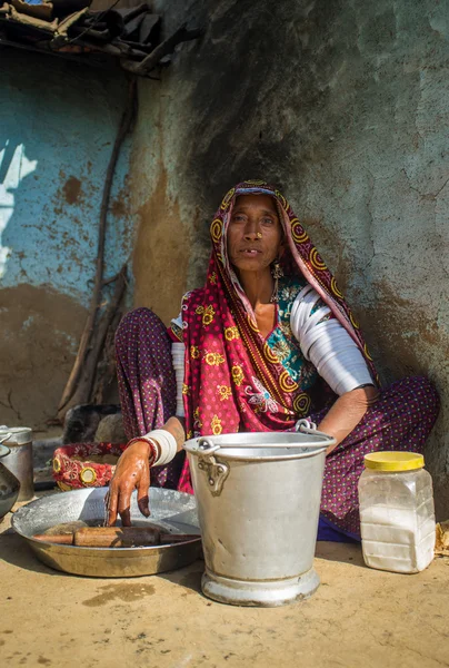 Rabari tribeswoman cleans dishes — Zdjęcie stockowe