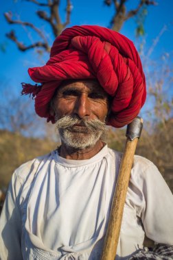 Rabari tribesman holds traditional axe