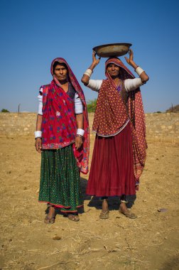Rabari tribeswomen stand in field
